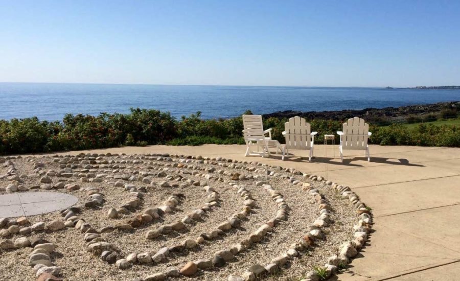 Peaceful stone labyrinth by the ocean with Adirondack chairs